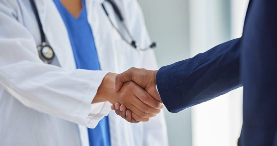 Business handshake and doctor partnership in a hospital with thank you and greeting gesture. Clinic, healthcare and professional deal shaking hands with agreement and contract success for b2b